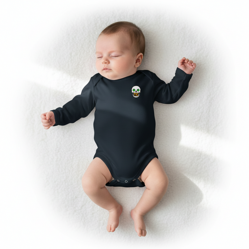 Baby wearing a black onesie with a smiley face design on a white blanket